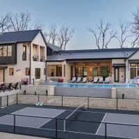 The lakefront mansion with its pool and court
